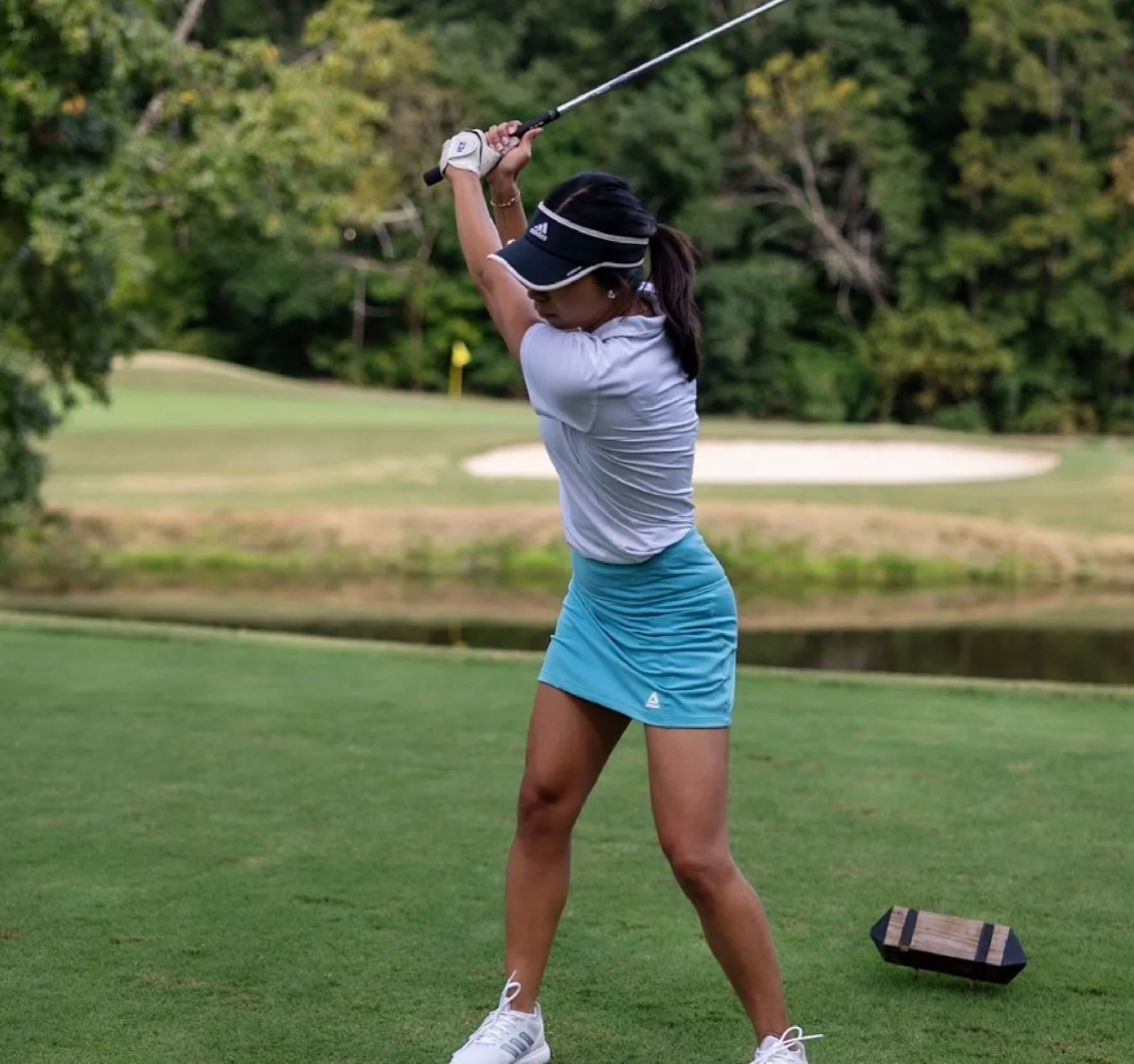 Valeria following through on her golf swing at The Valley Golf Course
